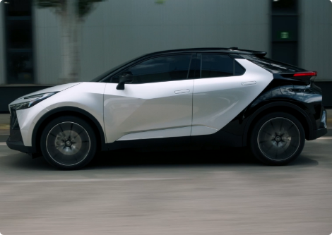 Toyota városi terepjáró fehér és fekete színben, az úton halad.