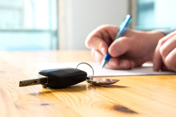 Keys next to person taking notes