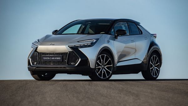 Seitenansicht eines roten Toyota C-HR Plug-in Hybrid angeschlossen an einer Ladesäule