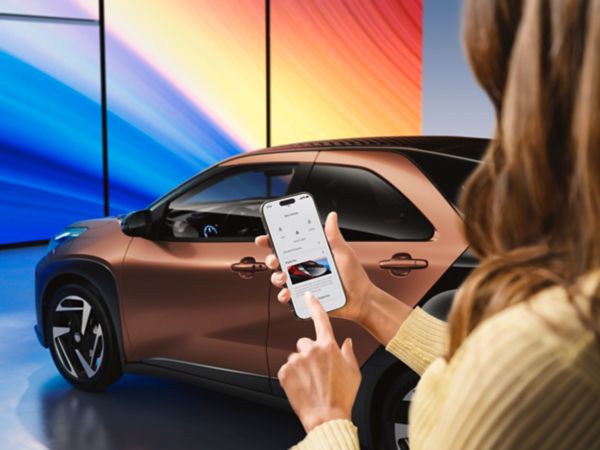 Aygo X vairuotojas atidaro automobilį telefonu
