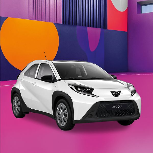 Ein weißer Toyota Aygo X auf einem bunten Hintergrund.