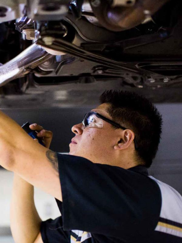 man working underneath a Lexus car