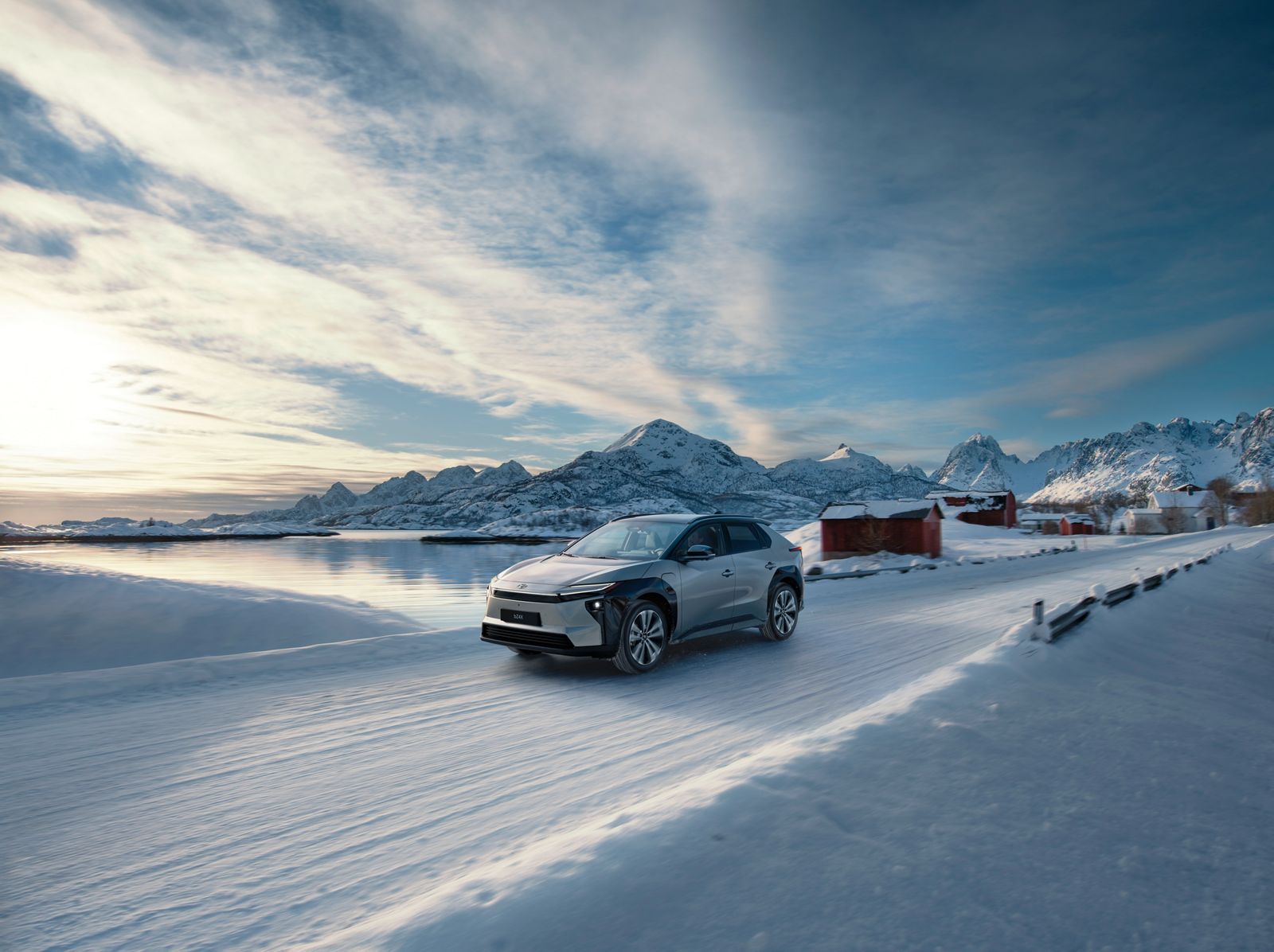 A Toyota bZ4X drives across a snow-covered landscape 