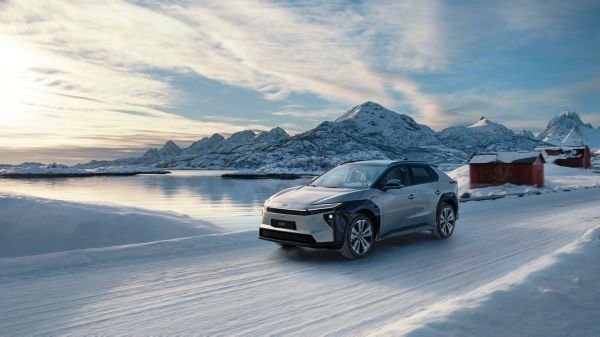 A Toyota bZ4X drives along a snow-covered road