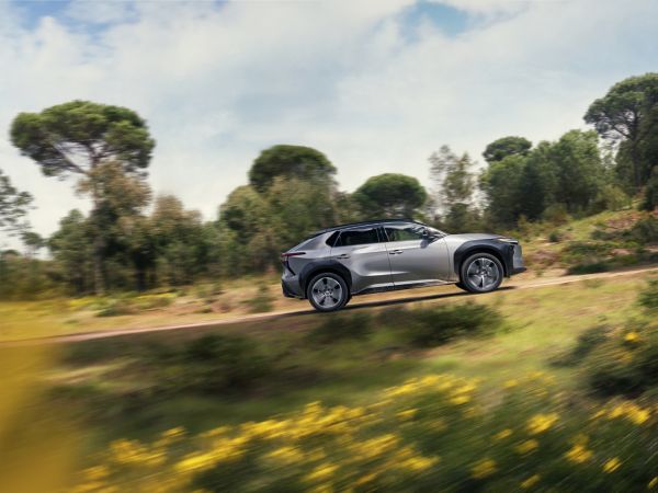 Ein silberner SUV fährt auf einer Landstraße durch grüne Landschaft und zeigt, wie vielseitig Firmenwagen in Österreich auch außerhalb des Stadtverkehrs genutzt werden können.