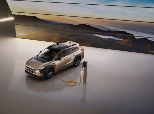 bZ4X Touring die oplaadt in een studio, met op de achtergrond een gigantisch LED-scherm waarop een bergketen te zien is.