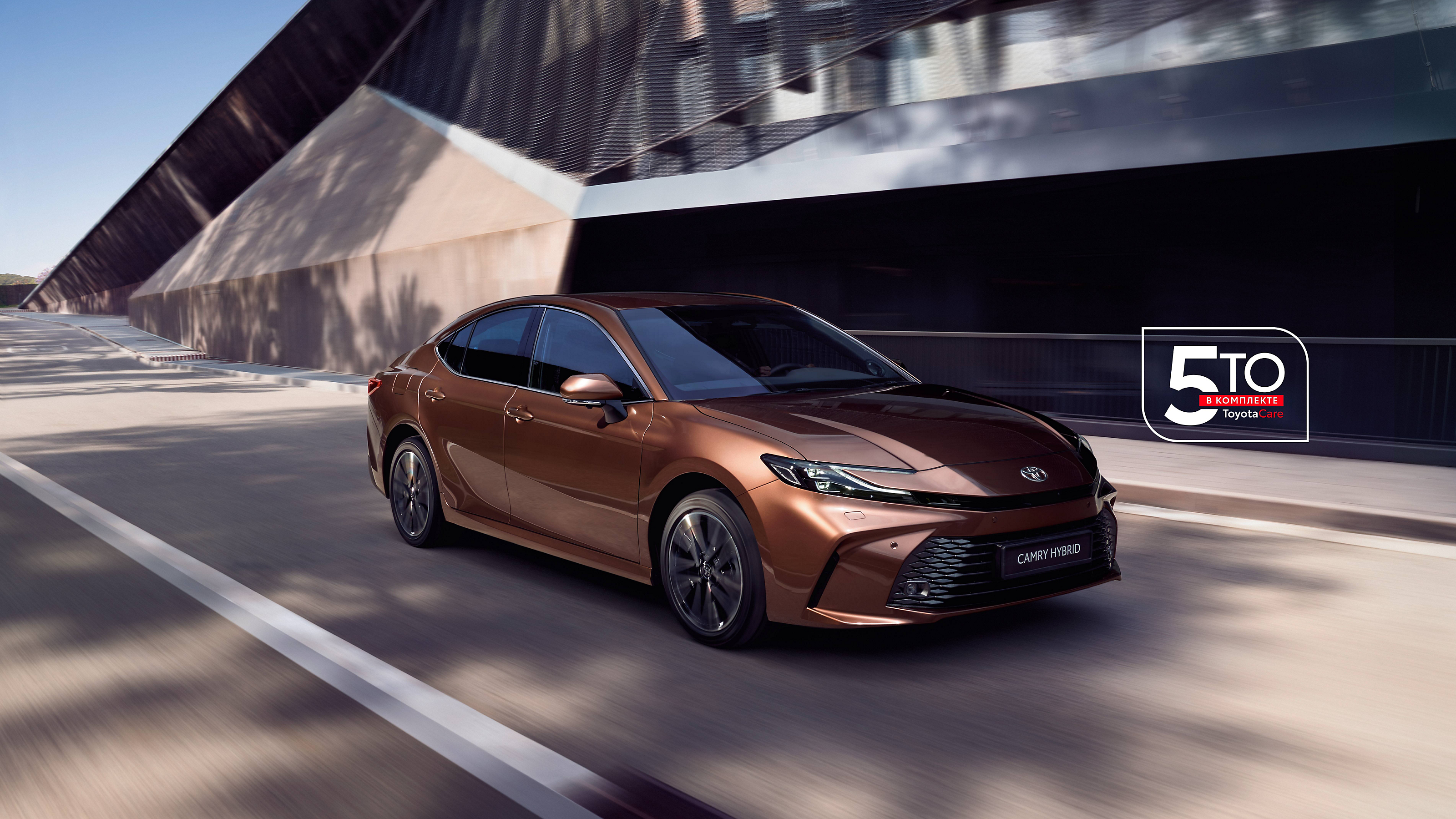 Гибридная Toyota Camry едет по городу