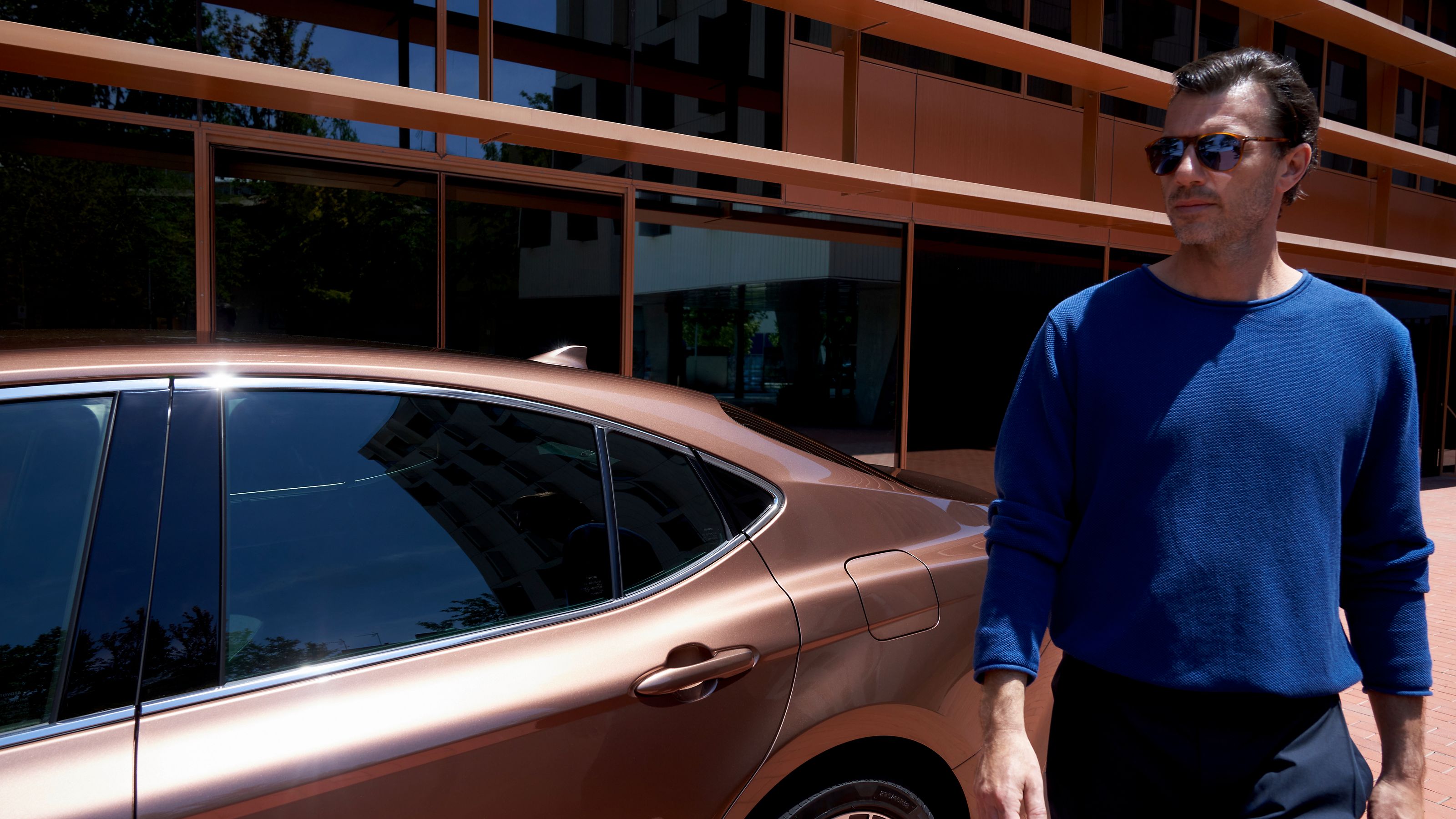 Владелец Toyota Camry обходит свой автомобиль.