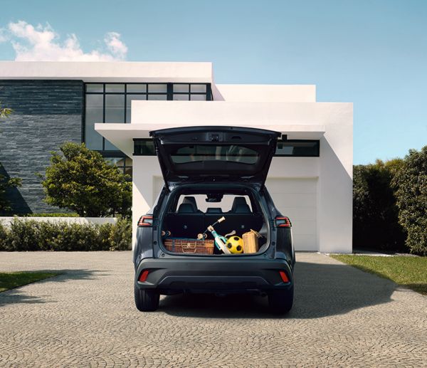 Gif showing the new Corolla Cross panoramic roof and the spacious rear seats, while the car is parked outside a sleek, modern home