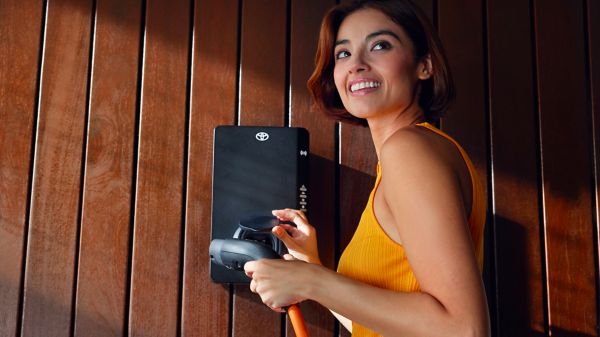 Femme qui va recharger son véhicule électrique