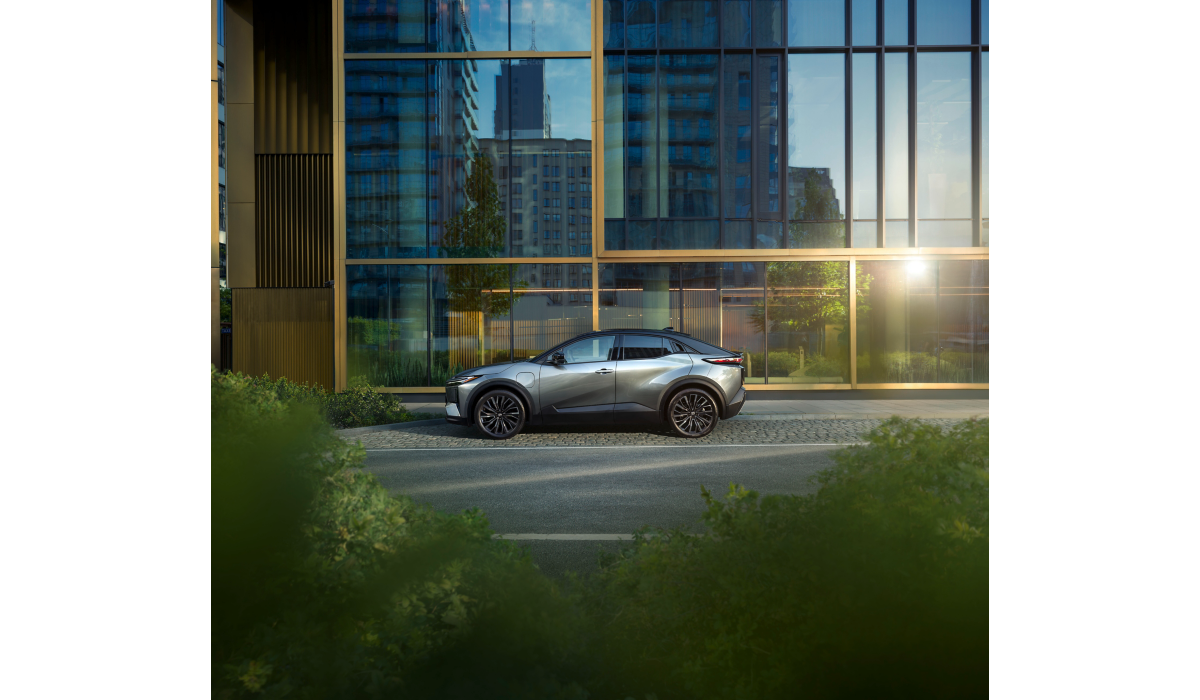 Toyota C-HR+ lagður við götu við háhýsi 