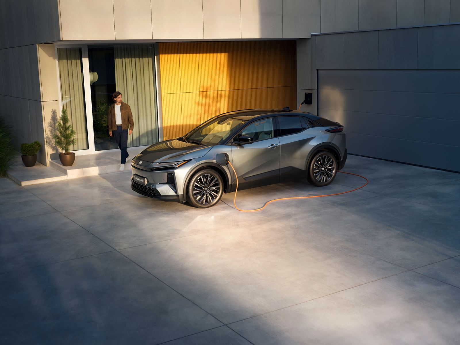 TOYOTA C-HR+ parked and charging outside a house      