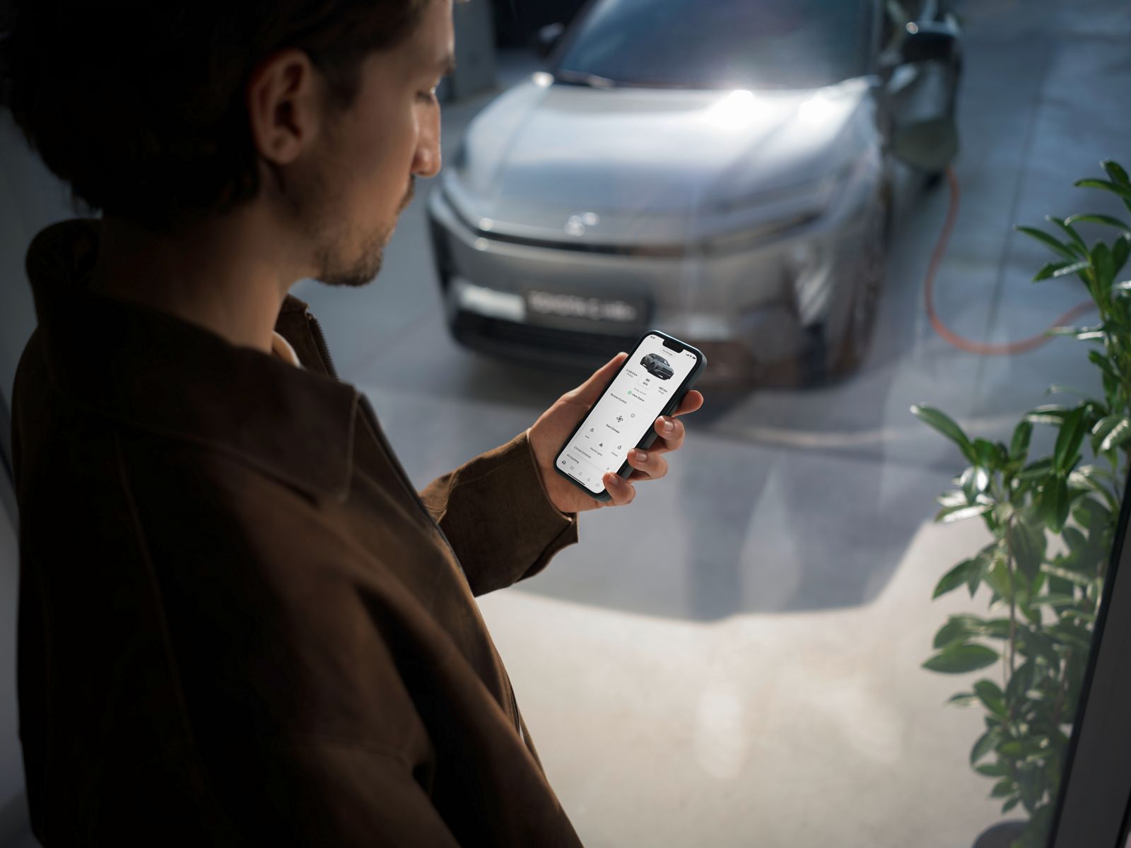 Toyota C-HR+ driver checking the MyToyota app on their phone