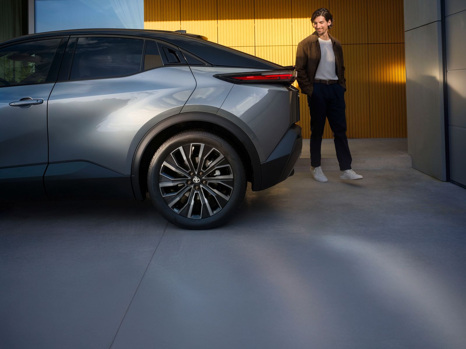 Toyota C-HR+ driver admiring the rear lines of the car