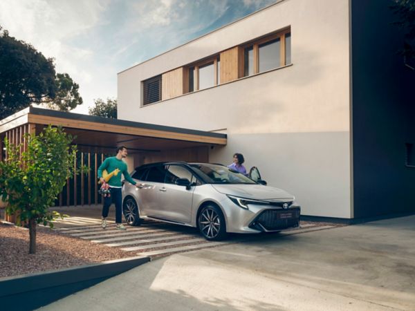 Woman walking past Toyota Corolla Touring Sports