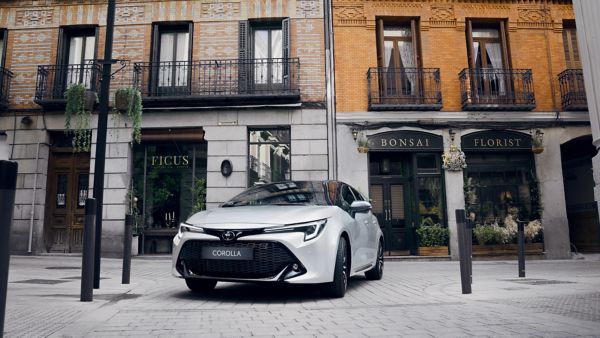 grey Toyota Corolla Hatchback driving on city road