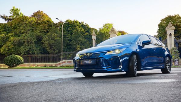 Светло син Toyota corolla sedan хибрид в движение