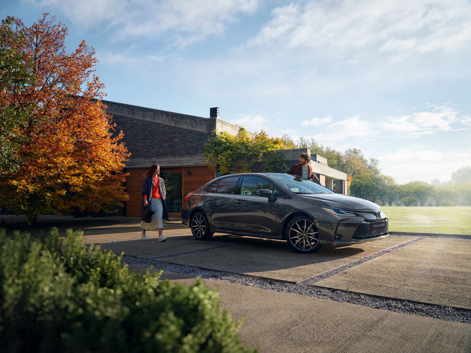 Majitel kráčející ke své Toyotě Corolla Sedan