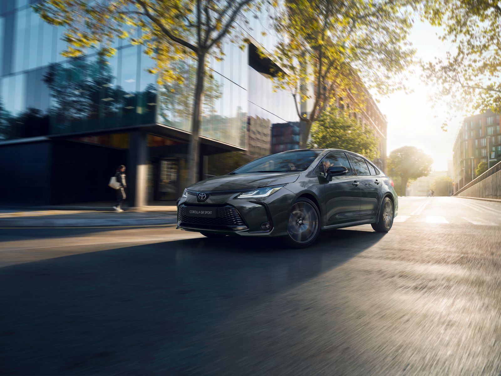 Toyota Corolla седан се движи в града през деня 