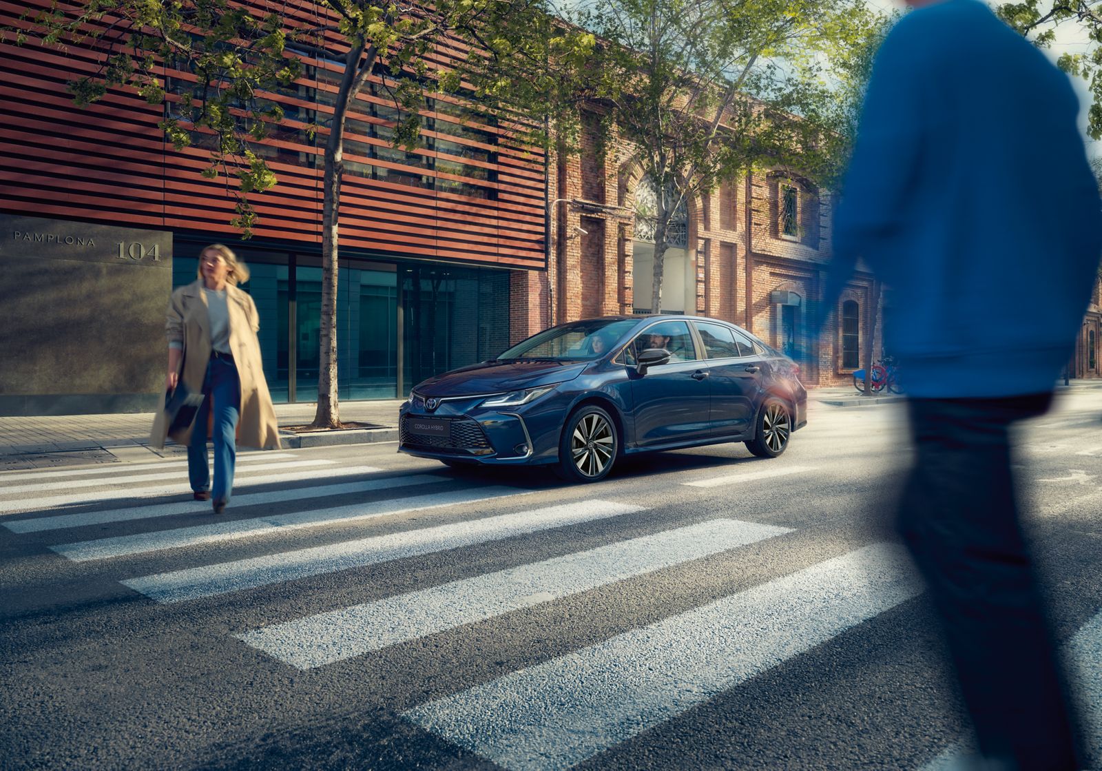 Um Toyota Corolla Sedan circula pela cidade em um dia ensolarado