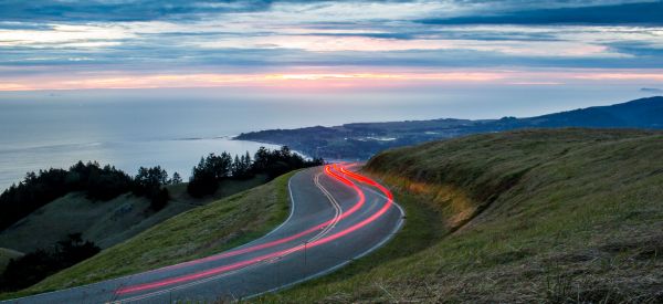 Car light trails on scenic road.