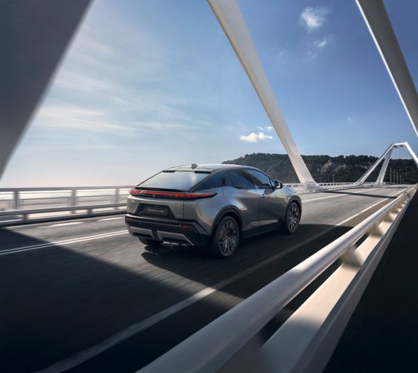 A Toyota C-HR+ drives across a spectacular bridge