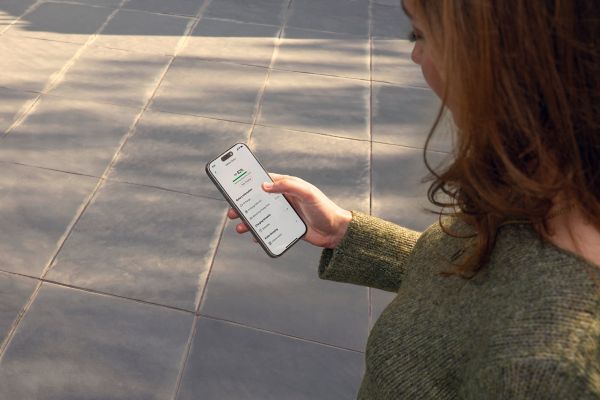 A Toyota C-HR+ owner checks their battery status using the MyToyota smartphone app.