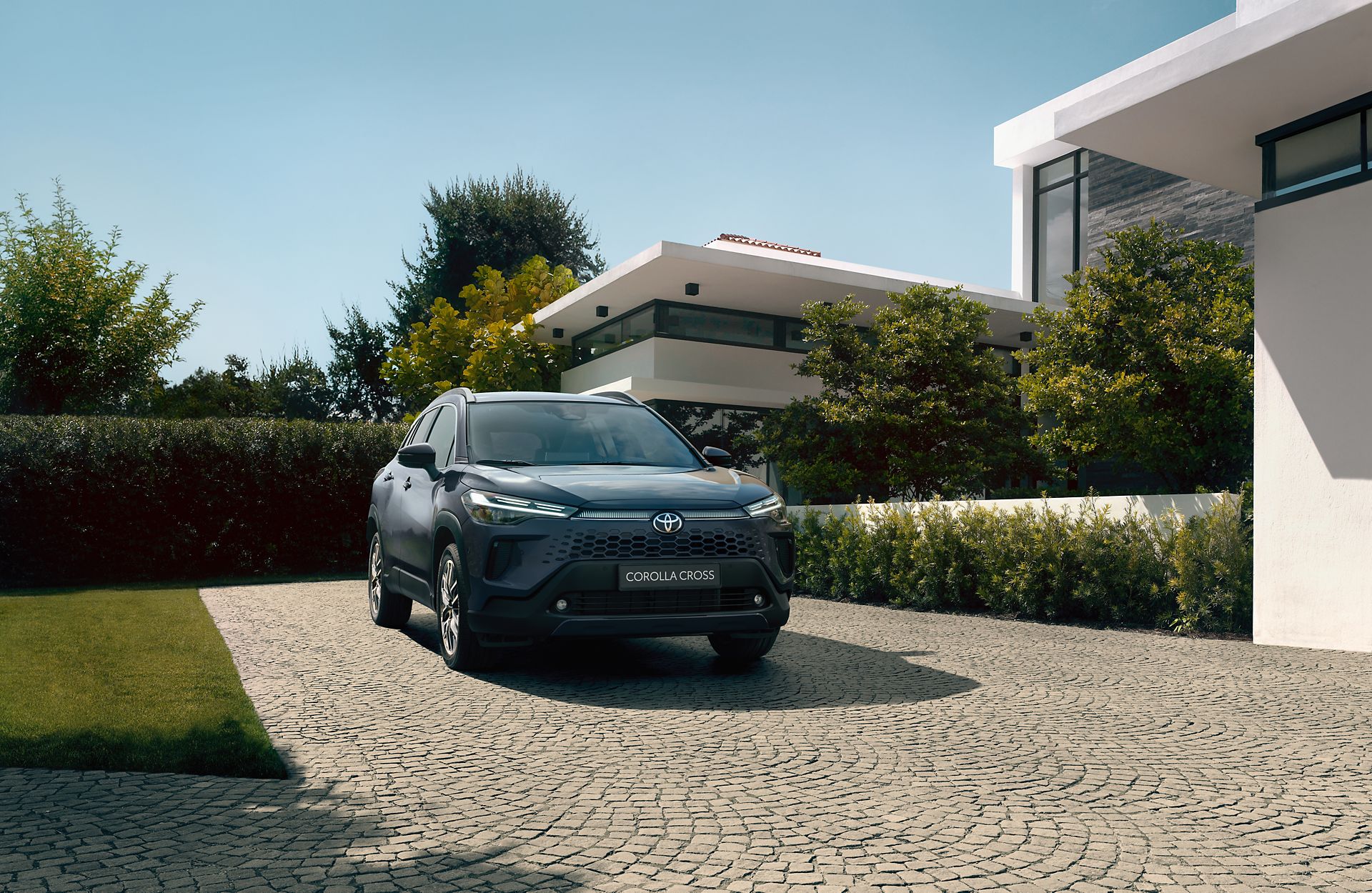 Nieuwe Toyota Corolla Cross geparkeerd voor stijlvol familiehuis.