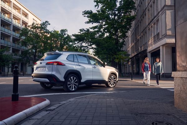 Witte Toyota Corolla Cross maakt een bocht