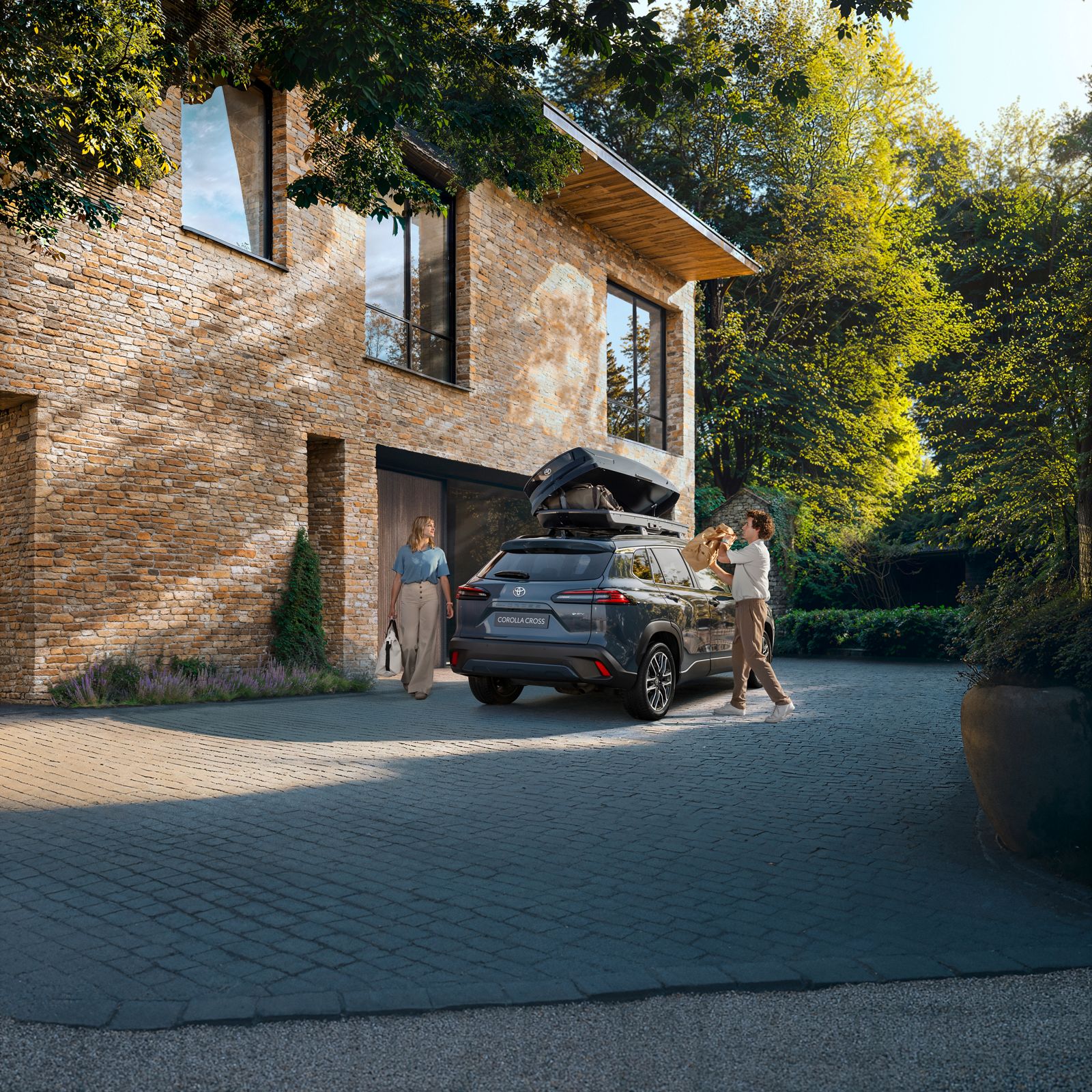 A family packs their Toyota Corolla Cross with luggage ahead of a trip