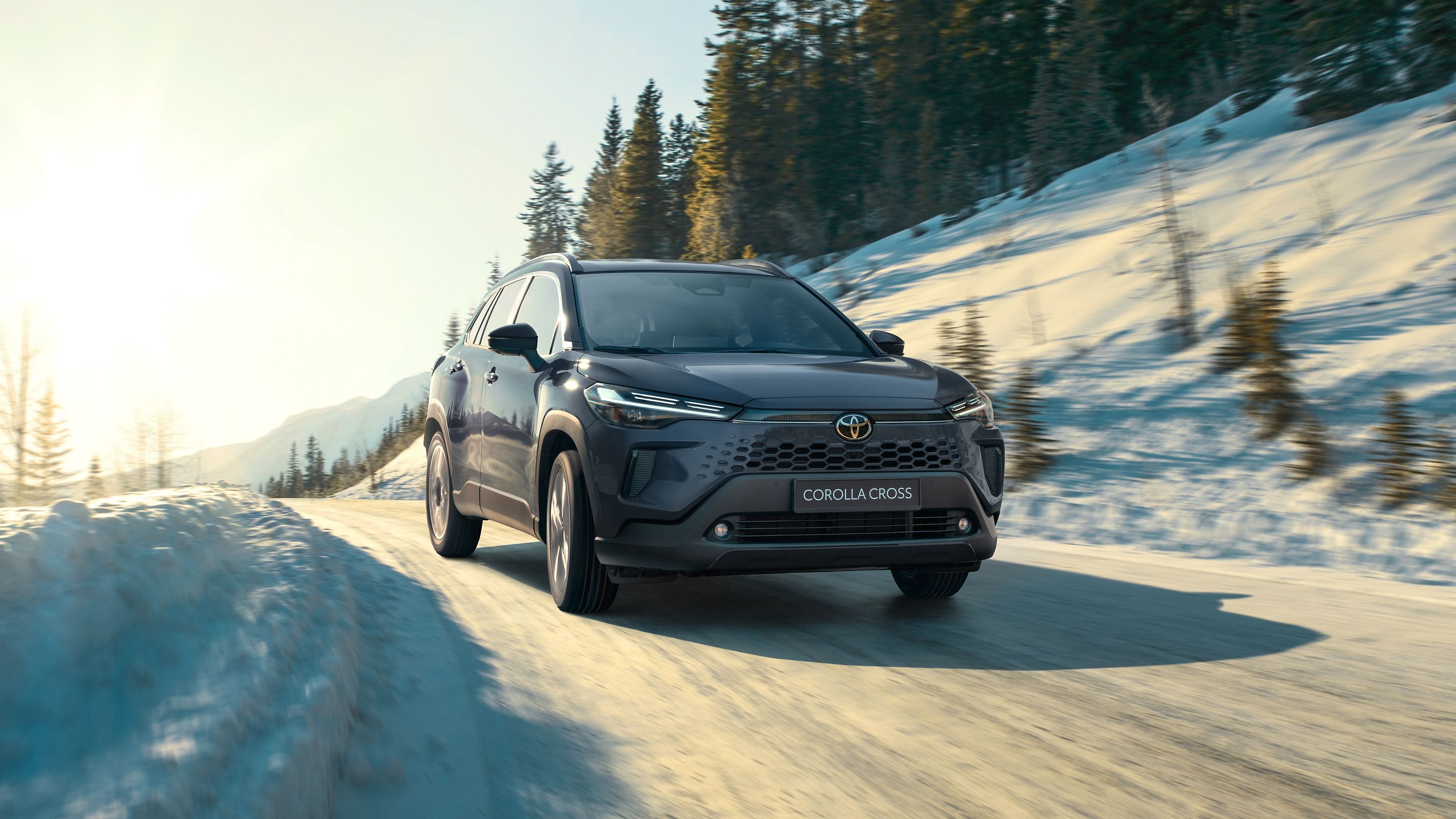 Toyota Corolla Cross jedzie zaśnieżoną górską drogą