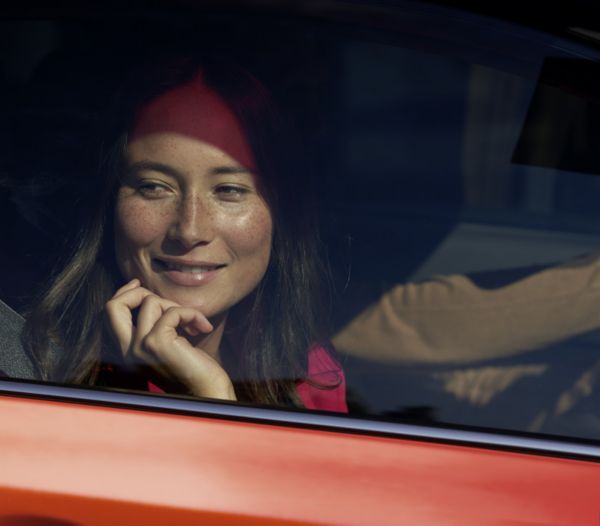 Vrouw lacht uit het raam van haar Toyota-auto