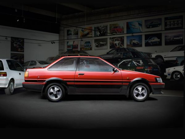 old style Red Toyota Corolla side angle