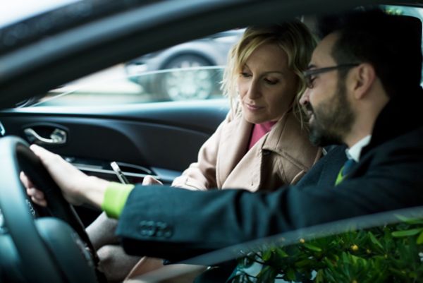 Frau läuft an einem Auto vorbei 