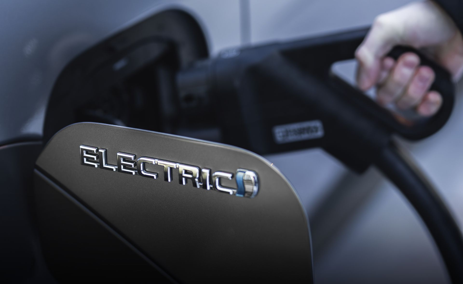 Zbliżenie miejsca do ładowania auta zelektryfikowanego podczas tej czynności.