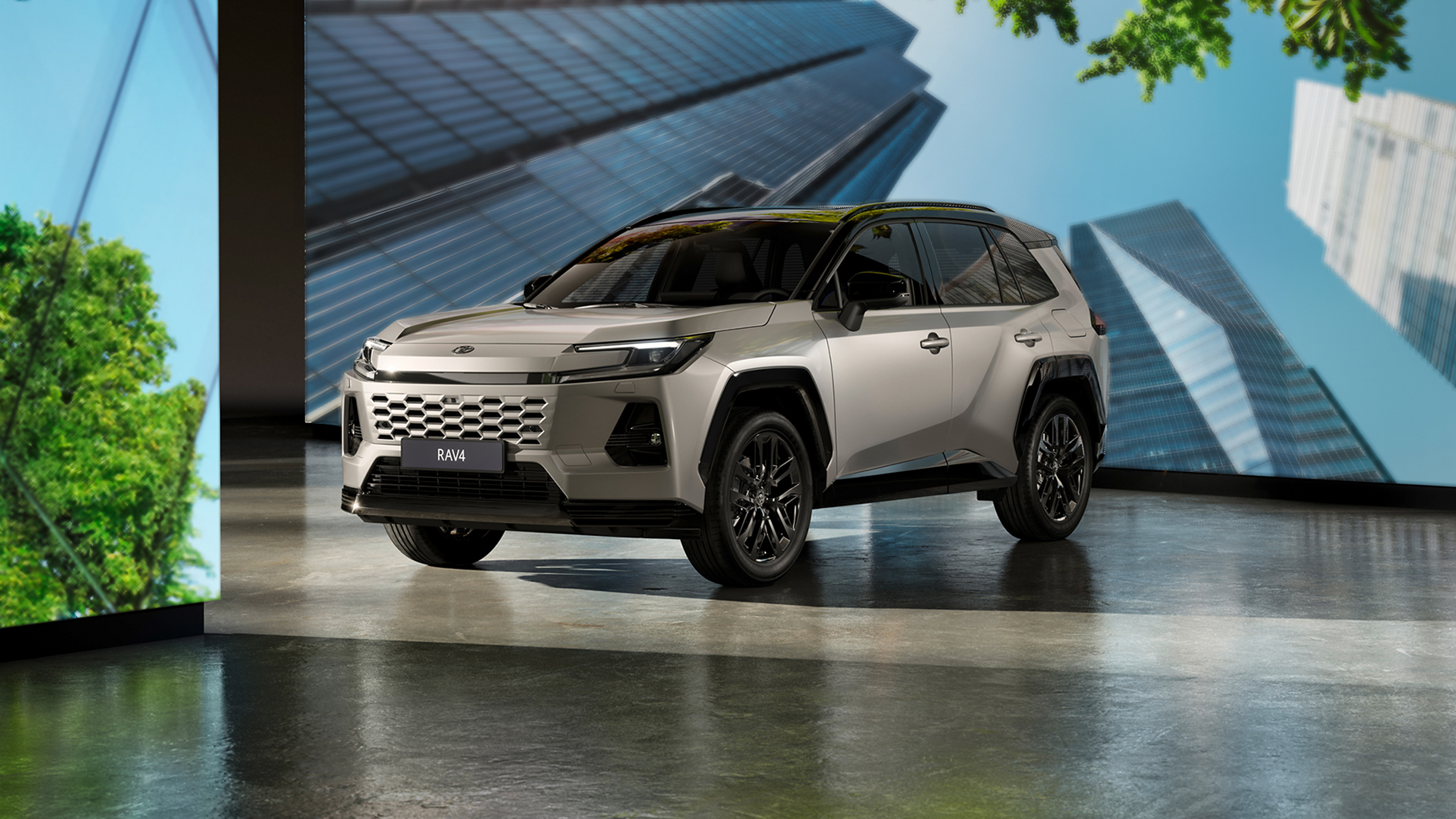 RAV4 Plug-in Hybrid and GR SPORT parked in front of screns showing forest scenes