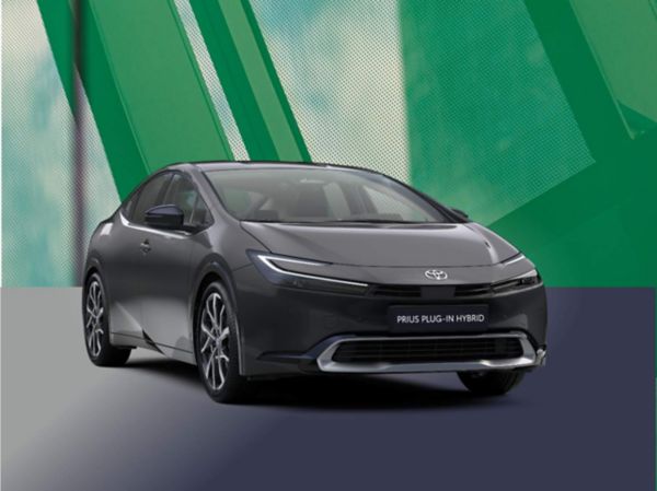 Toyota Prius Plug-in Hybrid in dunklem Grau, frontal leicht von links fotografiert vor stilisiertem grünem Hintergrund.