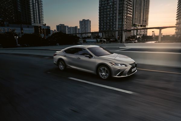 A silver Lexus ES driving through a city