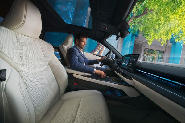 Un hombre caminando junto a un Lexus ES nuevo estacionado