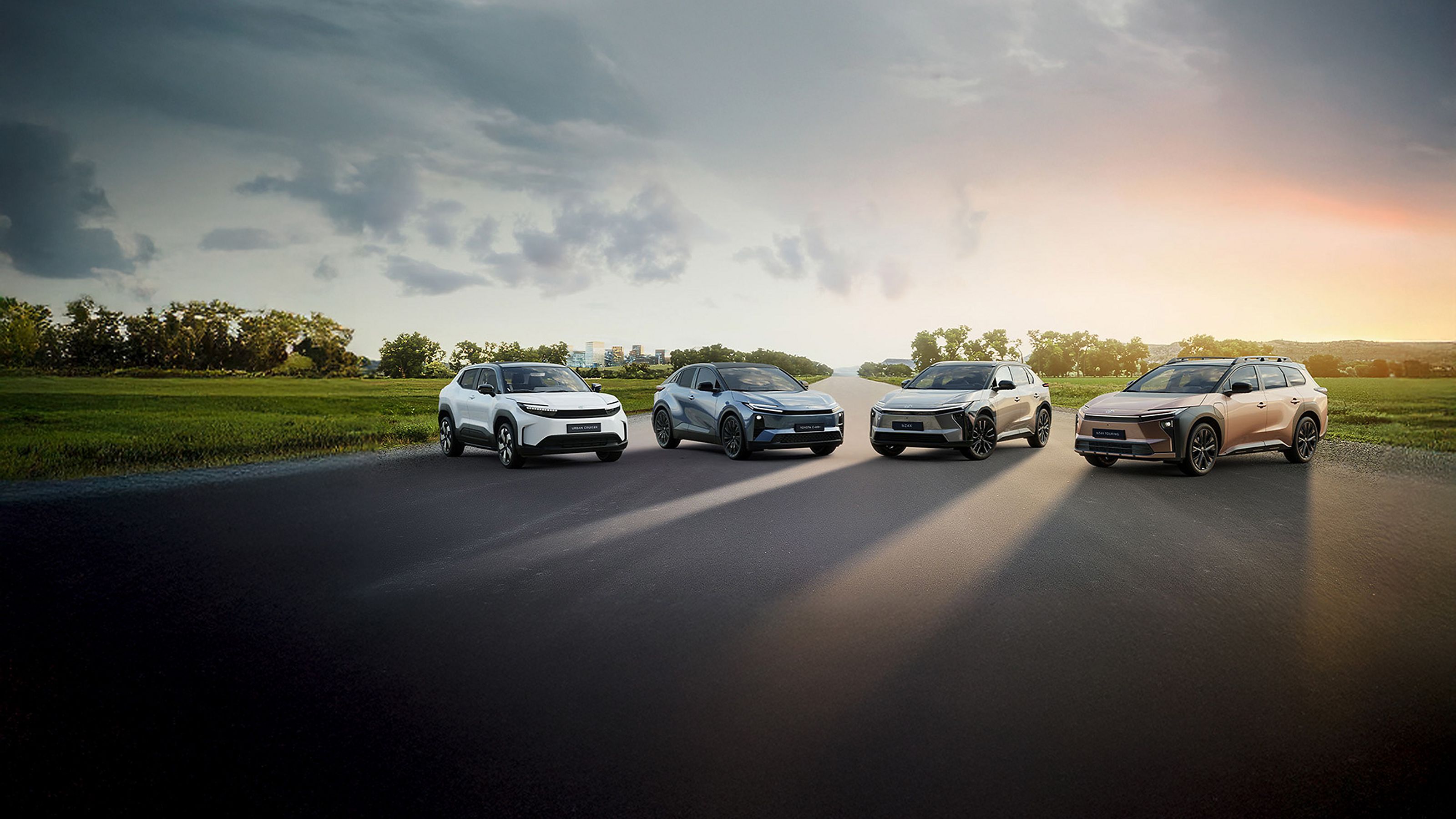 Quatres voitures éléctriques Toyota garés sur une route dans la nature.