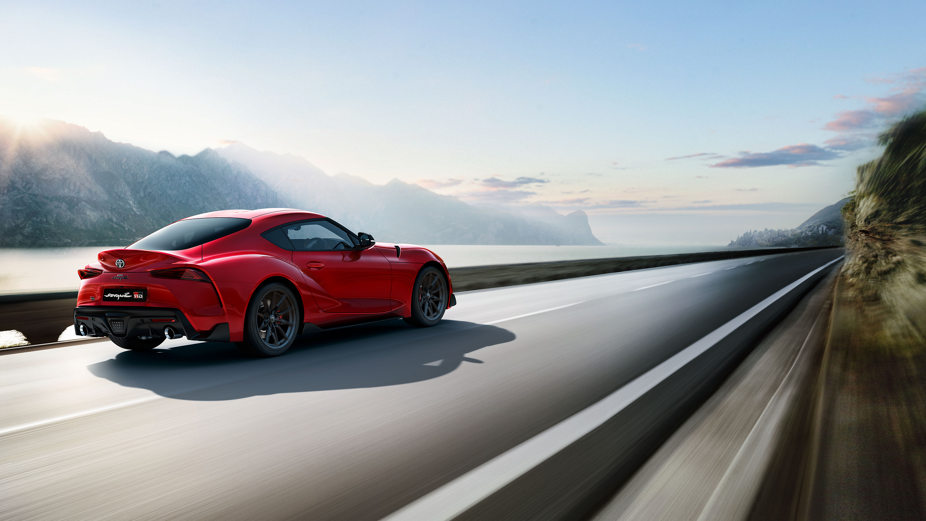 La Toyota GR Supra roule sur une route spectaculaire au bord d’un lac