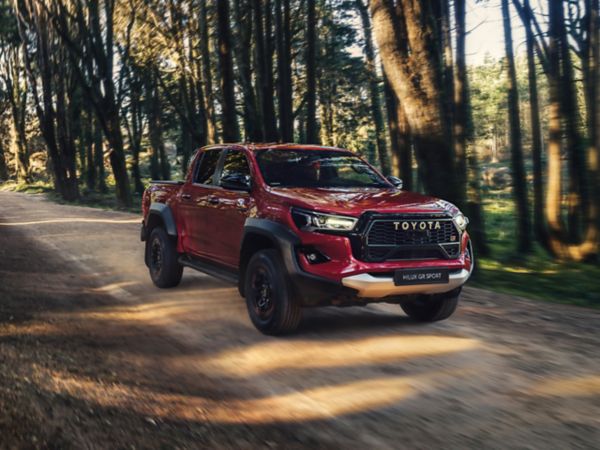 Ağaçlı yolda hızla ilerleyen Hilux GR SPORT