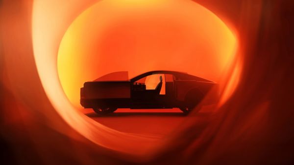 Futurisztikus Toyota koncepcióautó narancsszínű selyemlepel mögött a 2025-ös Japán Mobilitási Kiállításon