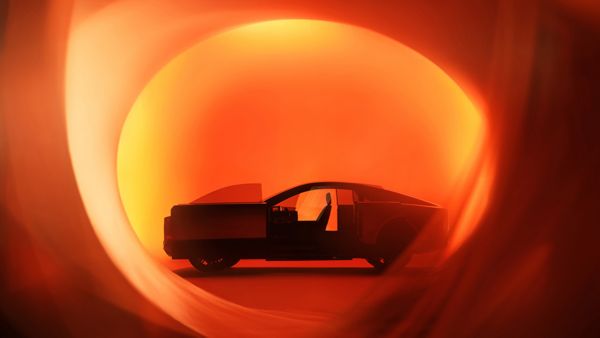 Futurisztikus Toyota koncepcióautó narancsszínű selyemlepel mögött a 2025-ös Japán Mobilitási Kiállításon
