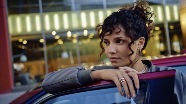 Une femme accoudée à sa voiture en LLD tout compris