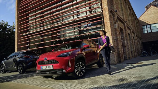 Woman walking by Toyota Yariss Cross