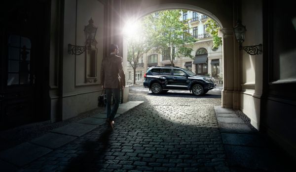 Toyota Land Cruiser parked in a street with a man walking towards it