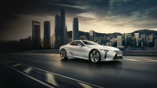 Lexus LC fährt an einer Stadt vorbei