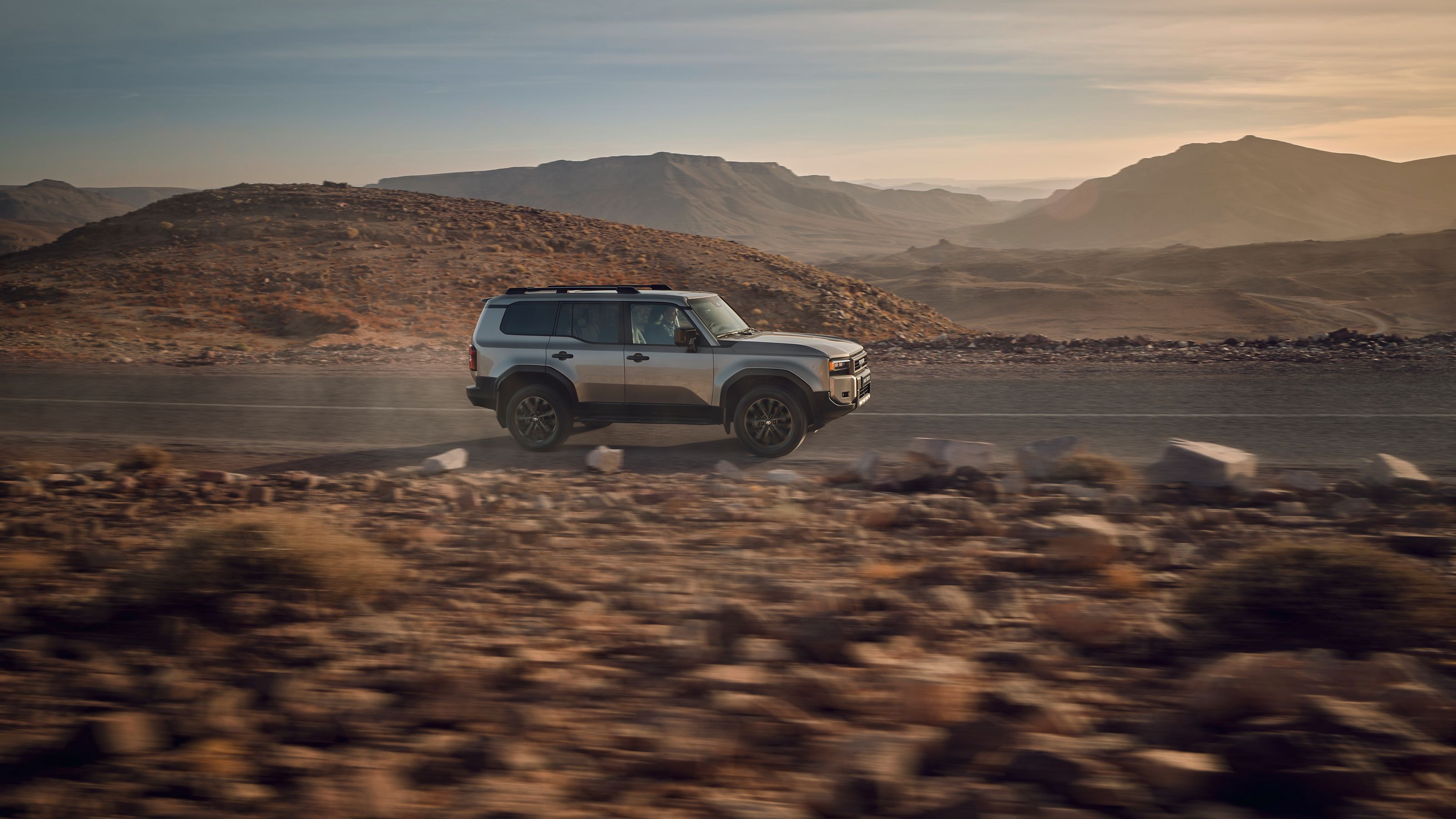 Land Cruiser driving on a road through the desert
