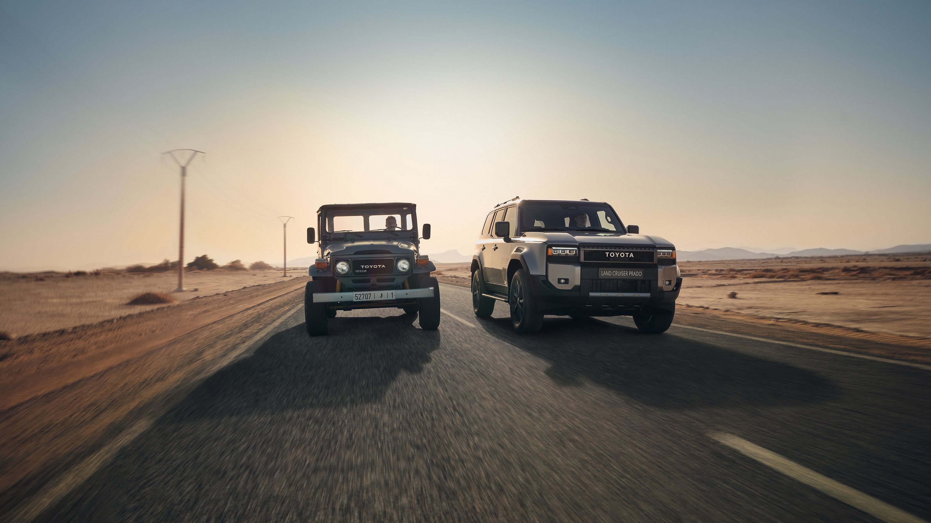 Two generations of Toyota Land Cruiser driving side by side